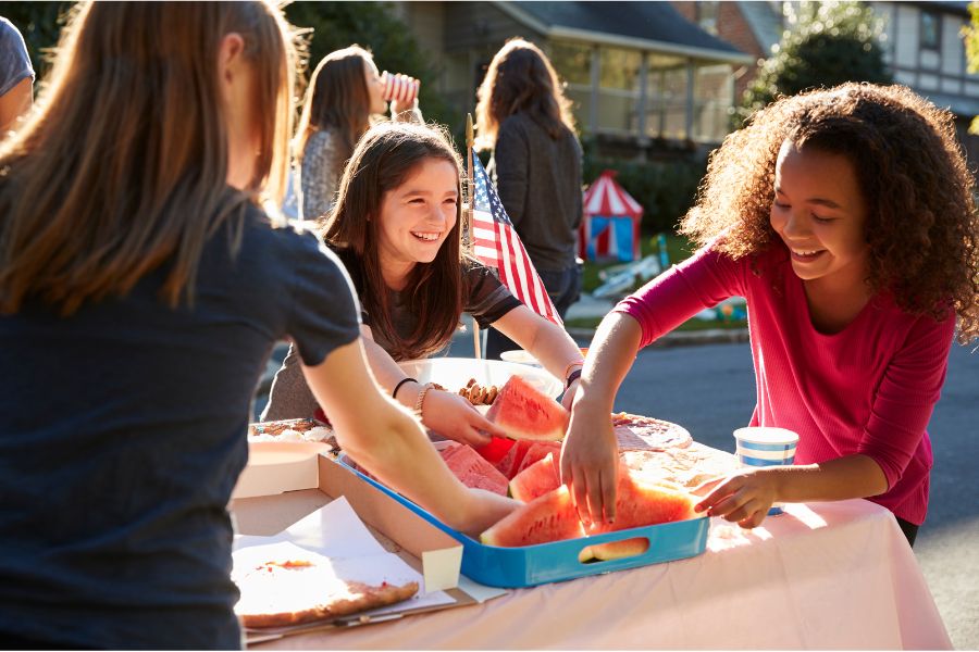 girls eating watermelon at picnic table